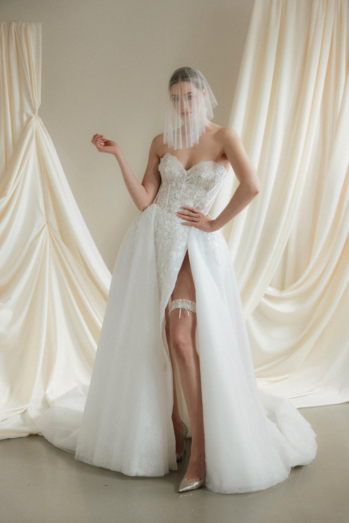 Bride wears a sheer tulle drop micro veil with pearl and crystal embellishments 
