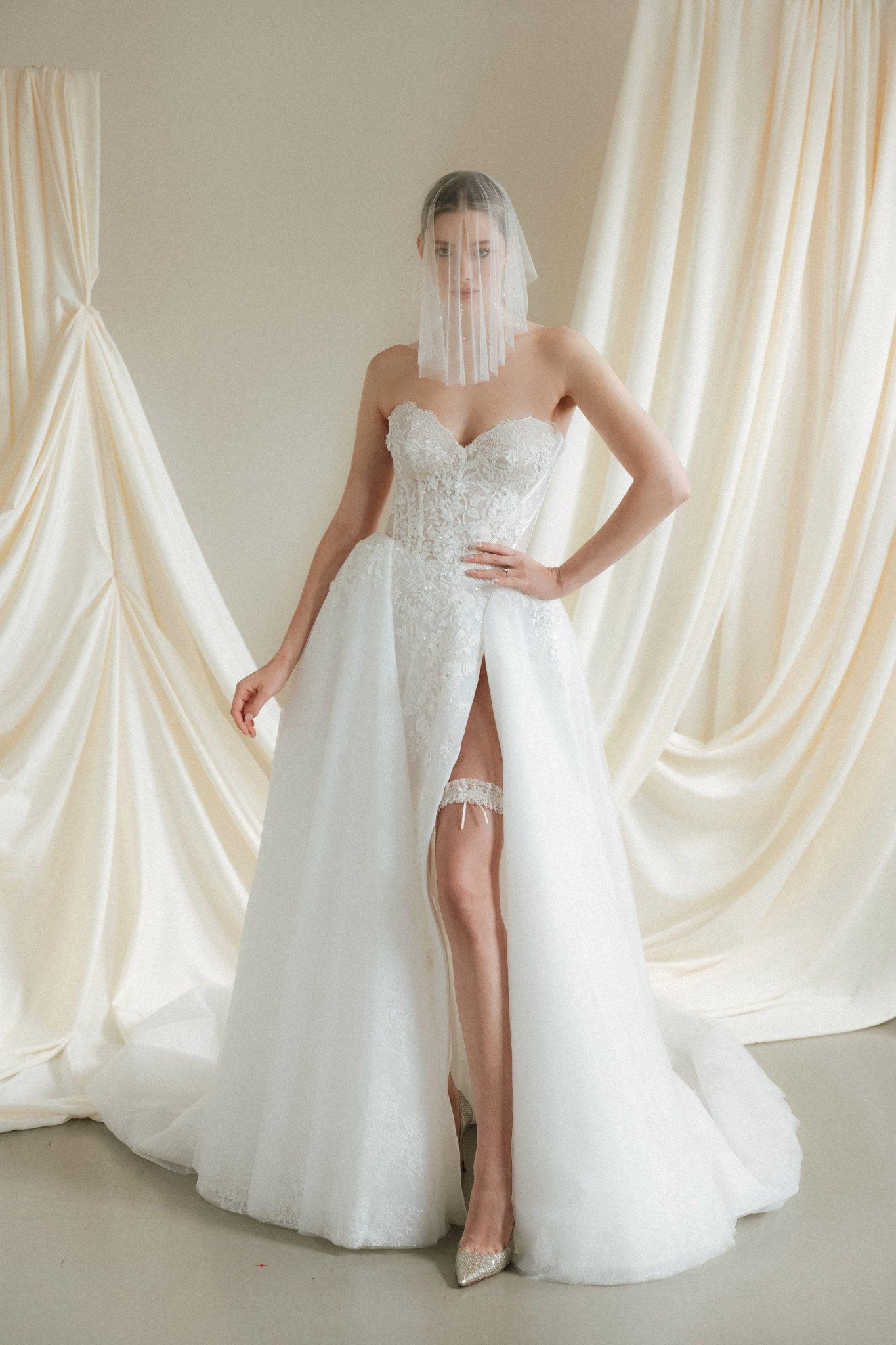 Bride wears a sheer tulle drop micro veil with pearl and crystal embellishments 