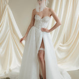 Bride wears a sheer tulle drop micro veil with pearl and crystal embellishments 