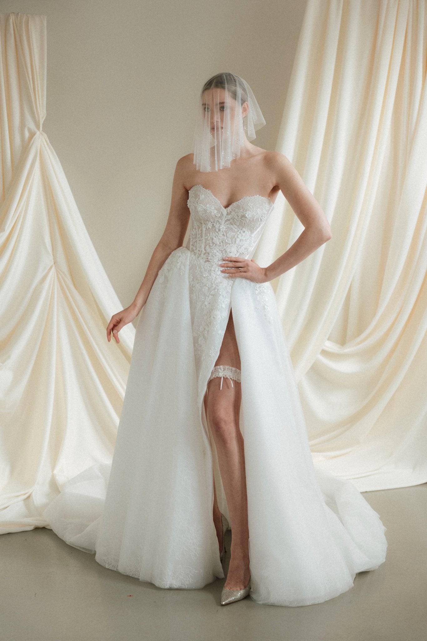 Bride wears a sheer tulle drop micro veil with pearl and crystal embellishments 
