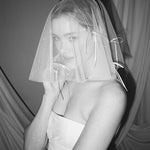 Bride wears a sheer tulle drop micro veil with pearl and crystal embellishments 