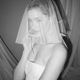 Bride wears a sheer tulle drop micro veil with pearl and crystal embellishments 