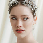 Woman wearing a wedding dress and tiara against a white curtain