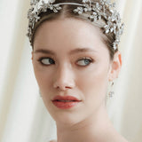 Woman wearing a wedding dress and tiara against a white curtain