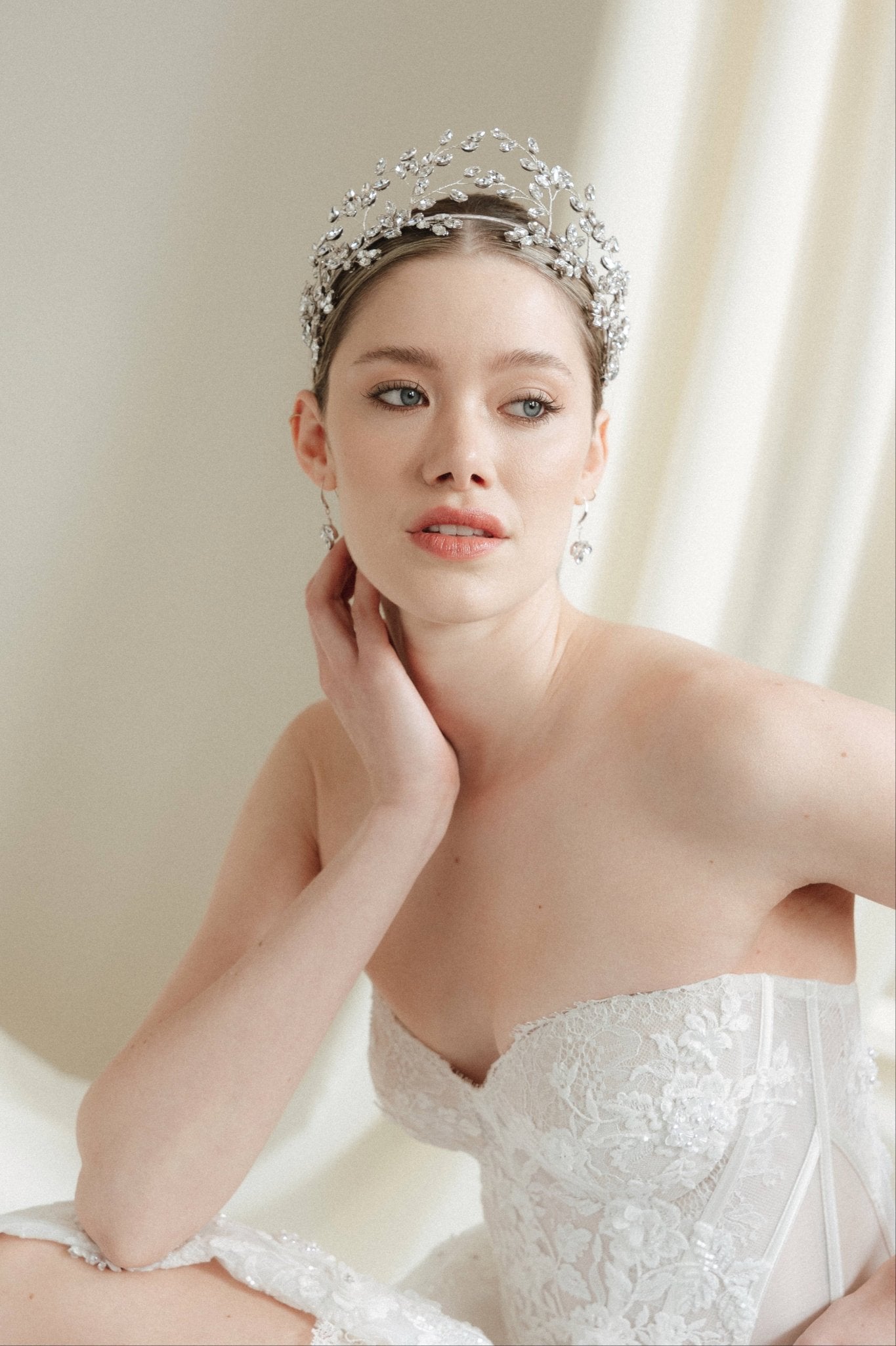 Woman wearing a silver tiara in a softly lit room