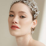 Woman wearing a silver tiara against a neutral background