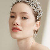 Woman wearing a silver tiara against a neutral background