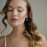 model wears round pearl earrings and matching necklace