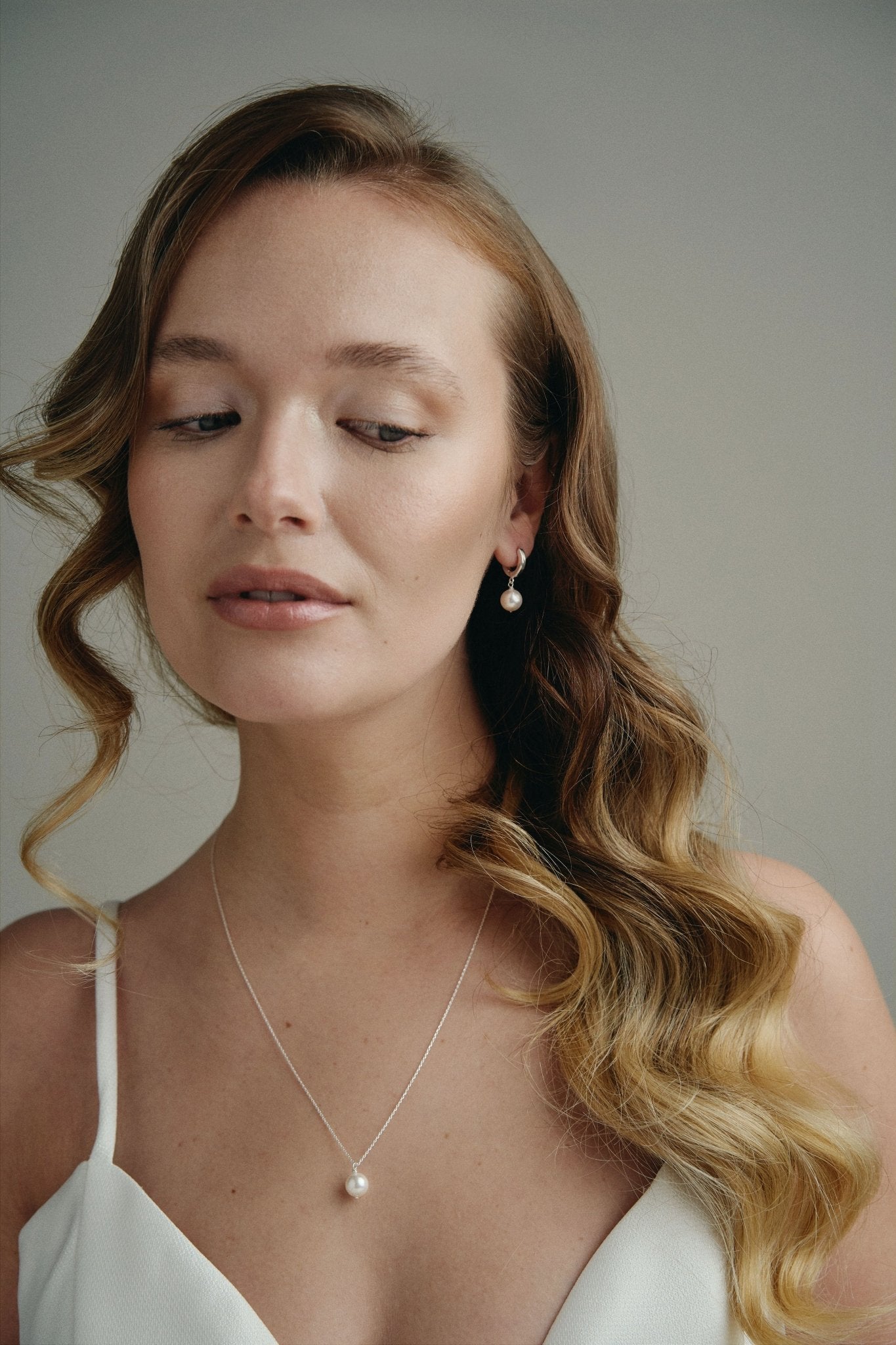 model wears round pearl earrings and matching necklace