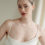 Bride wears a short merry widow mask birdcage veil with Perla pearl cluster hair pins and Dina Short gold round pearl stud drop earrings