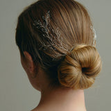 Wedding hair vine - model wears a pair of silver leafy delicate hair vines in the back of a low bun 