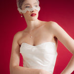 bride wearing a sheer micro veil with lace details against a red background