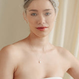 bride wears an ivory tulle mask style micro veil with small pearl embellishment with a baroque coin pearl necklace and crystl and pearl stud drop earring
