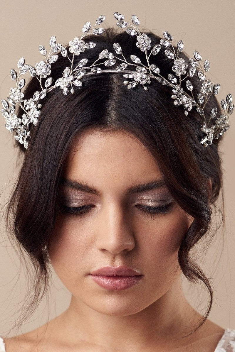 brunette model wears statement floral crystal wedding crown with matching hairpins 