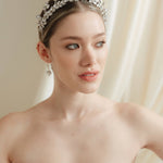 Woman wearing a wedding dress and tiara with a soft, neutral background