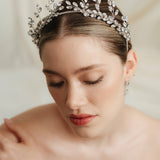 A bride wears an intricate silver crystal crown 