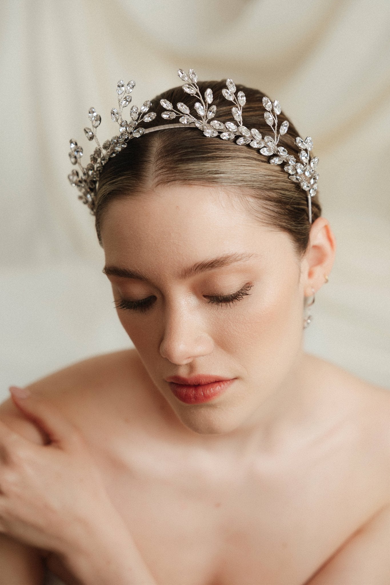 A bride wears an intricate silver crystal crown 