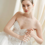 Woman in a white wedding dress with a tiara against an ivory draped  background