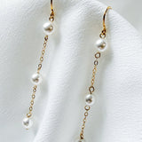 bride wears dainty pearl long drop earrings