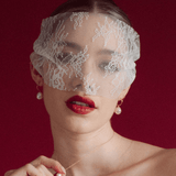 bride wears a sheer chantilly lace mask micro veil with gold hoop vegan baroque pearl earrings and matching necklace