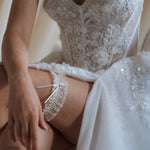 bride wears ivory lace garter with bow