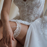 bride wears ivory lace garter with bow
