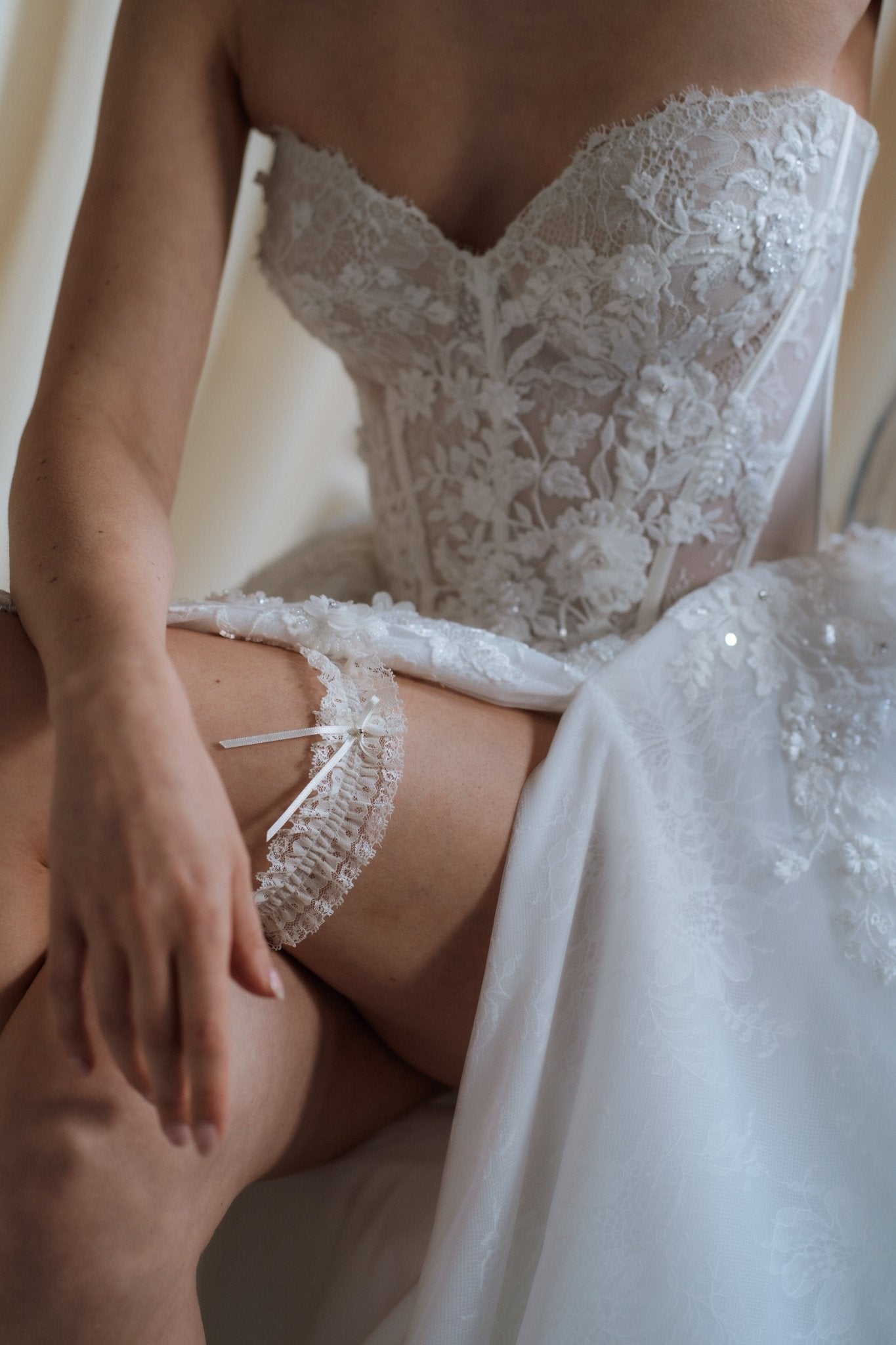 bride wears ivory lace garter with bow