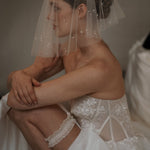 bride wears ivory lace garter with bow