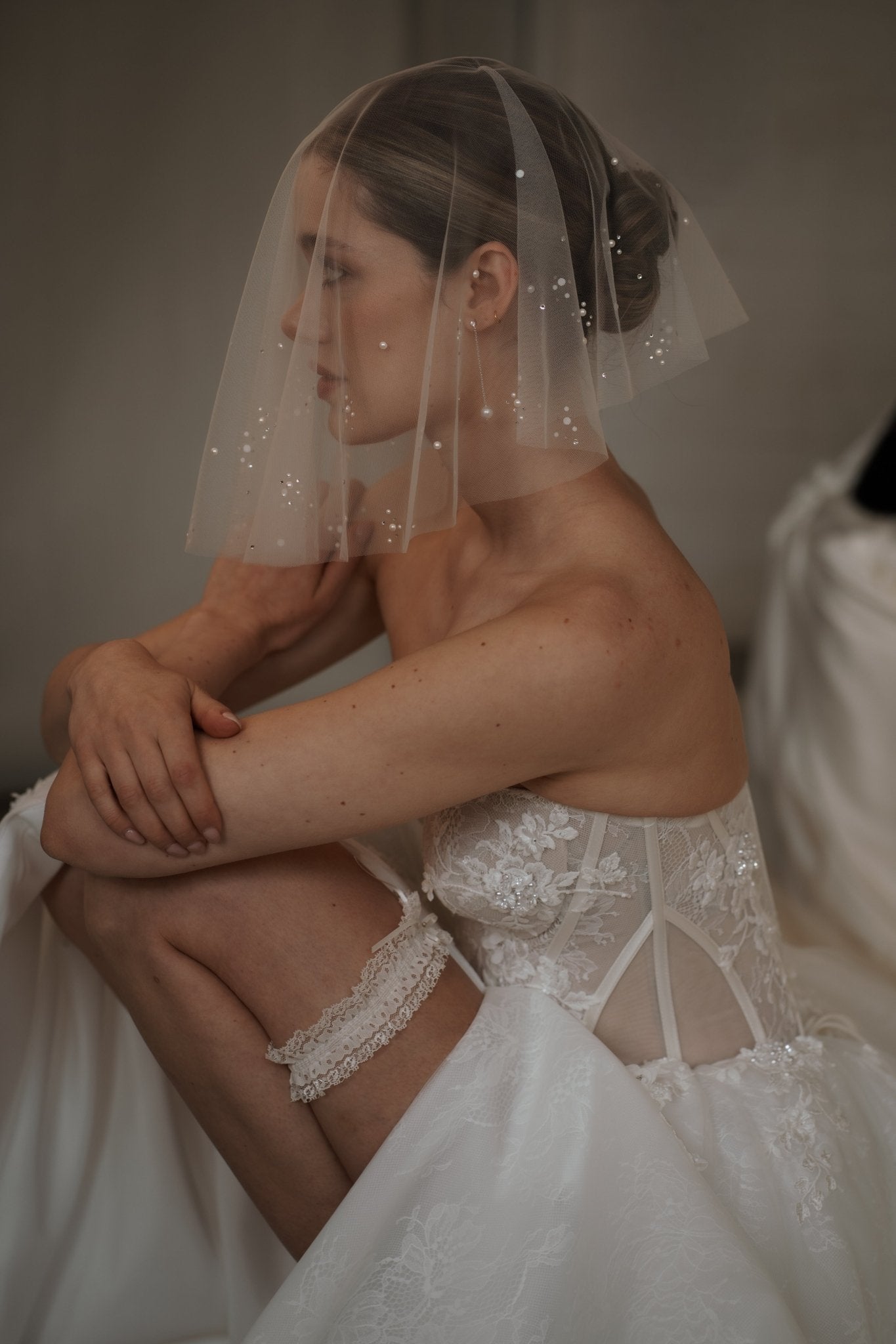 bride wears ivory lace garter with bow