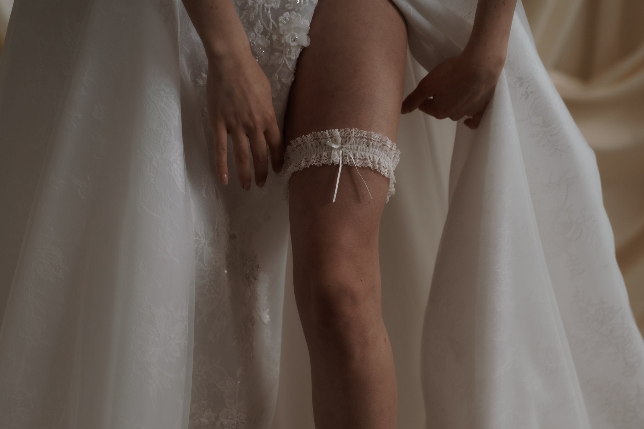 bride wears ivory lace garter with bow