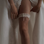bride wears ivory lace garter with bow