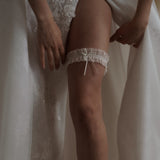 bride wears ivory lace garter with bow