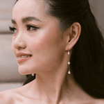 bride wears dainty pearl long drop earrings