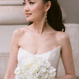 bride wears dainty pearl long drop earrings