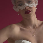 bride wears an ivory tulle mask micro veil with lace edging with gold hoop pearl earrings and gold baroque pearl necklace