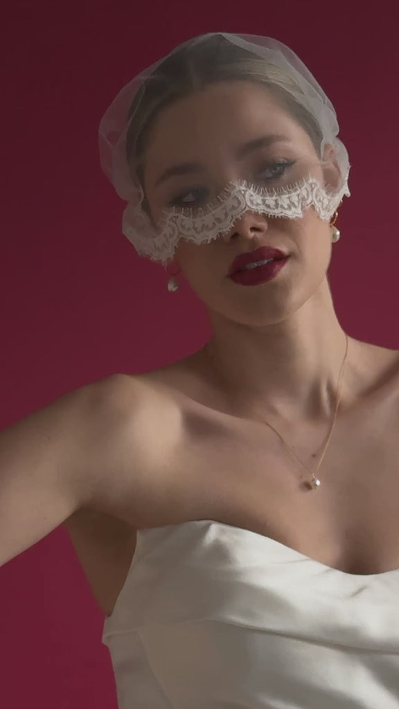 bride wears an ivory tulle mask micro veil with lace edging with gold hoop pearl earrings and gold baroque pearl necklace