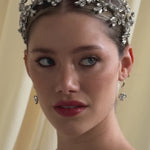 bride wears a silver crystal crown with matching drop earrings