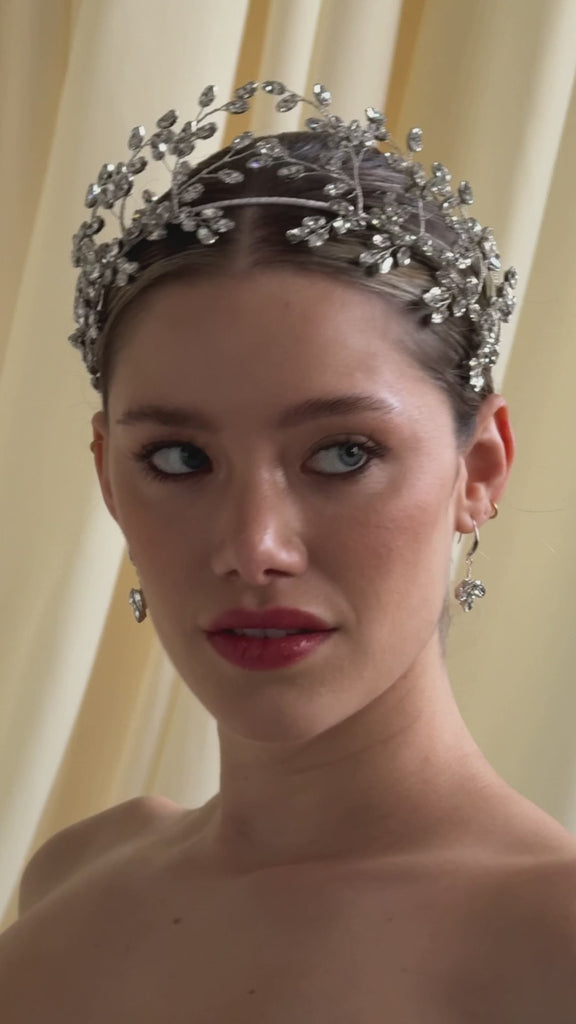 bride wears a silver crystal crown with matching drop earrings