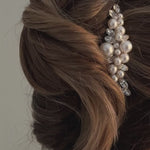 bride wears crystal and pearl cluster hair comb in side of a chignon updo