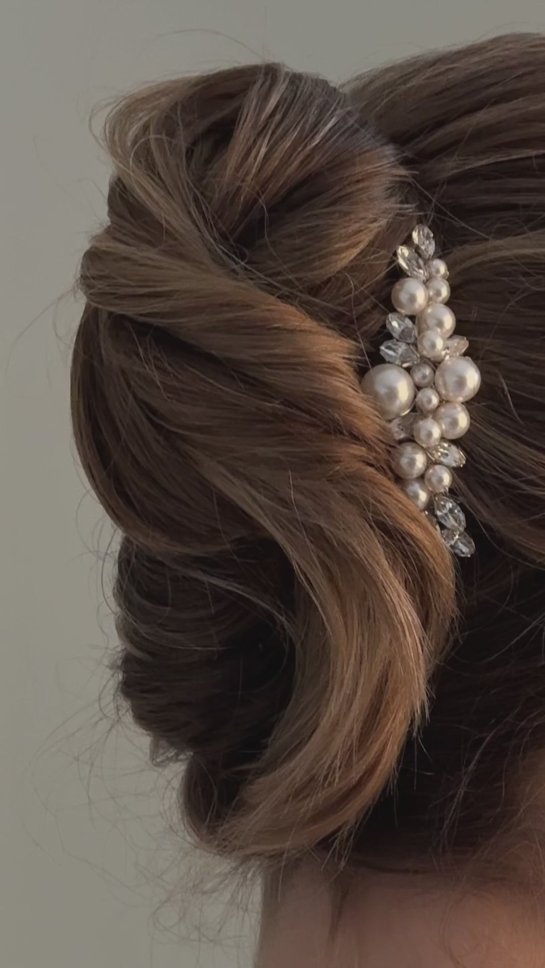 bride wears crystal and pearl cluster hair comb in side of a chignon updo