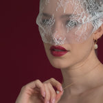 bride wears a lace mask style micro veilw with gold hoop baroque pearl earrings and matching necklace