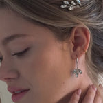 bride wears crystal leafy hair pims with matching crystal long drop earrings
