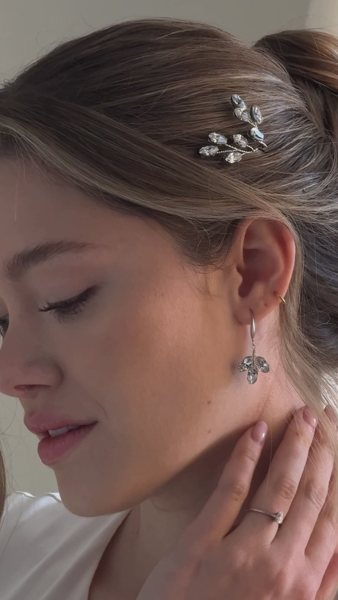 bride wears crystal leafy hair pims with matching crystal long drop earrings
