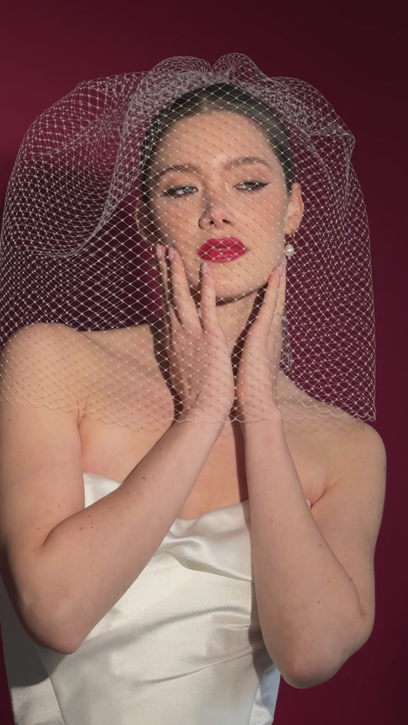 bride wears an oversized blusher style birdcage veil