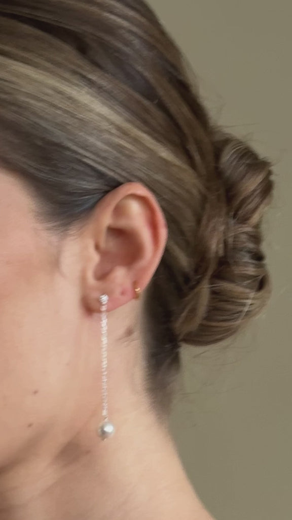 bride wears long drop silver crytal and round pearl earrings