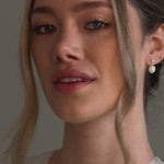 bride wears crystal and pearl stud drop earrings