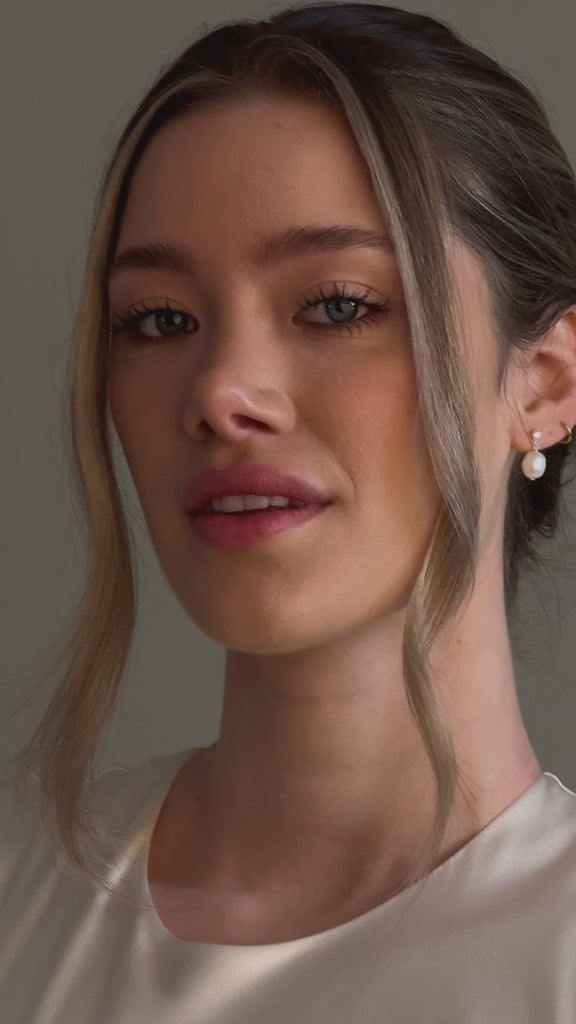bride wears crystal and pearl stud drop earrings