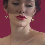 bride wears a black tulle mask style micro veil with gold crystal drop earrings and gold baroque coin necklace
