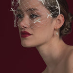 bride wears a bow birdcage veil headband