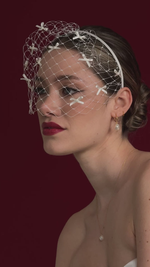 bride wears a bow birdcage veil headband